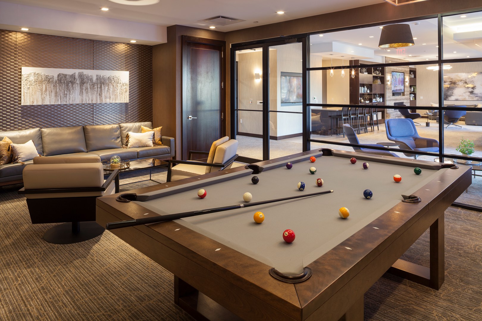 A sophisticated social retreat featuring ample seating, modern décor, and a billiards table for casual recreation.